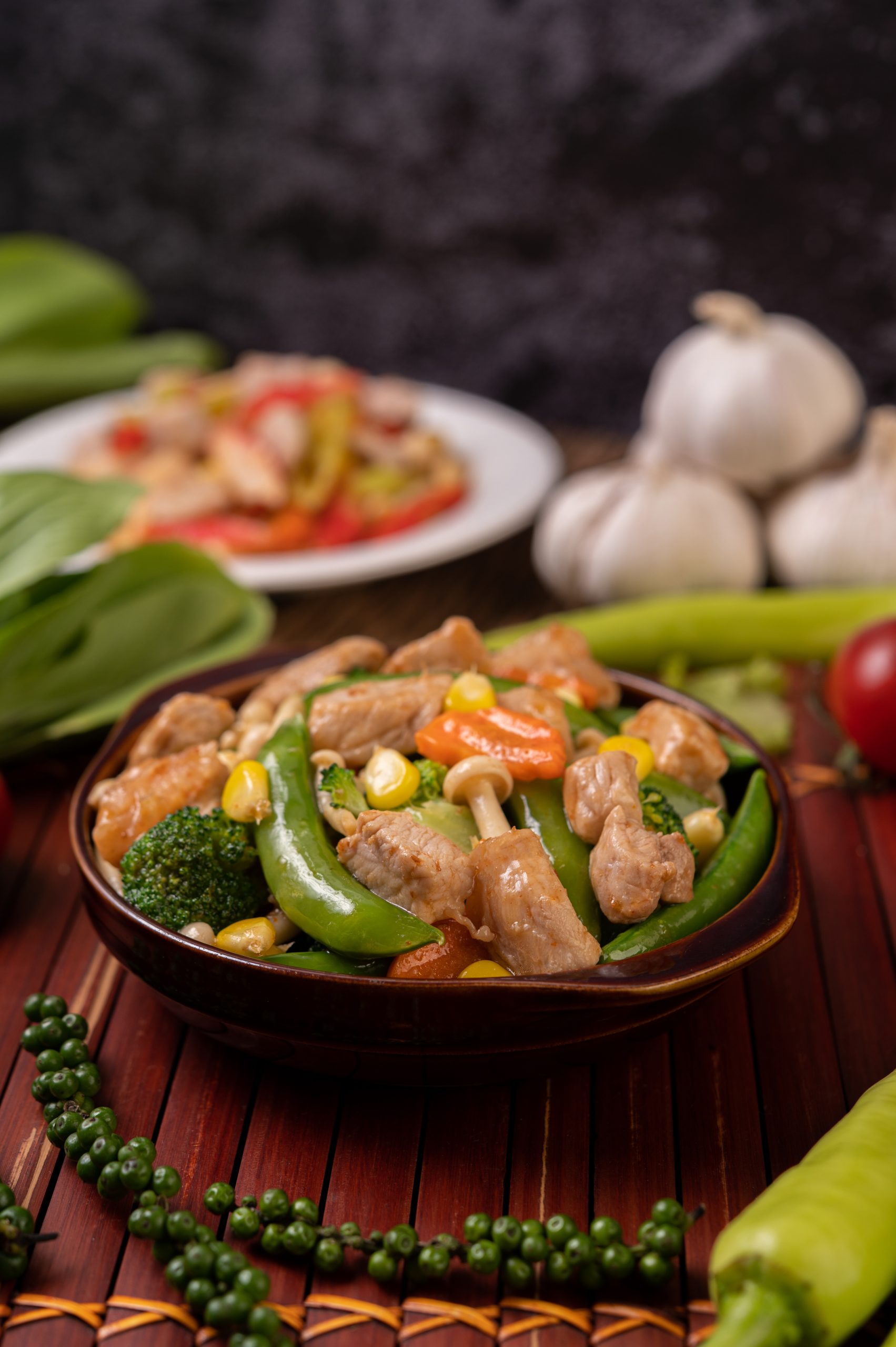 Stir-fried mixed vegetables containing Green peas, carrots, mushrooms, corn, broccoli, and pork.